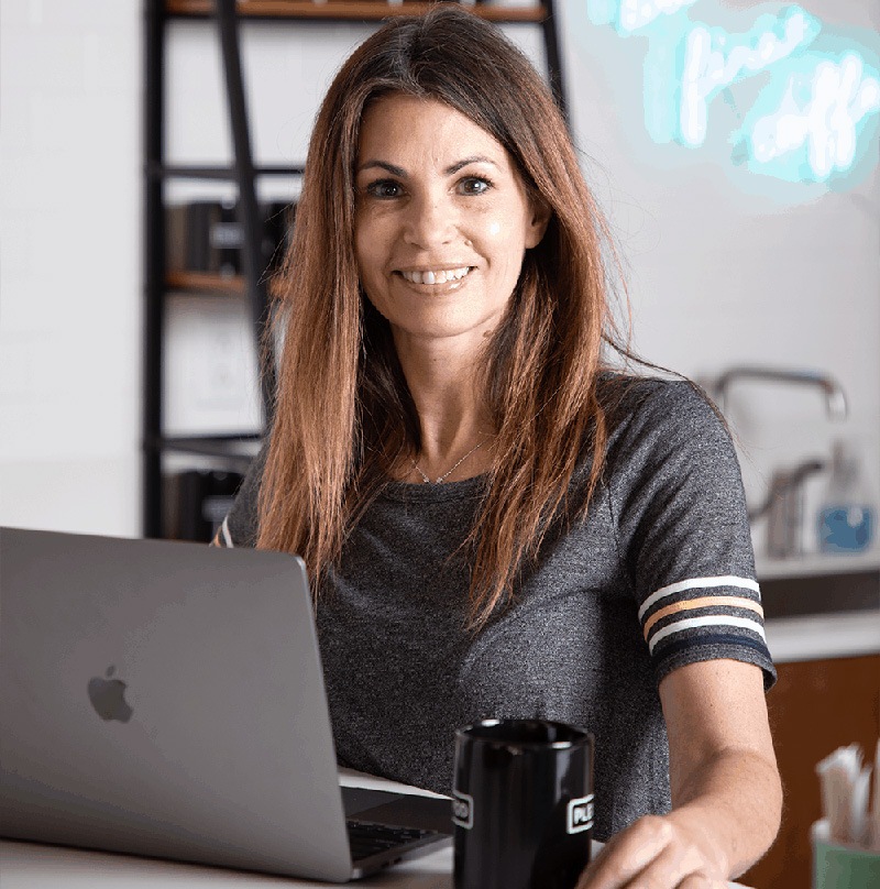 Woman smiling and drinking coffee working on her IT career training
