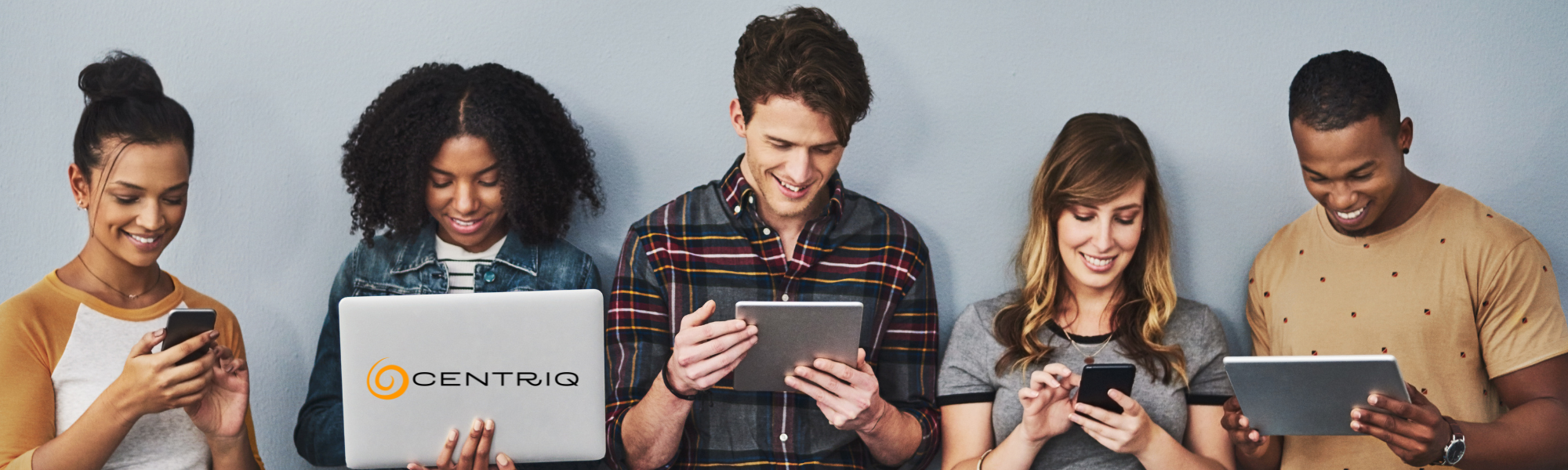 A group of students on their laptops and devices. SMiling